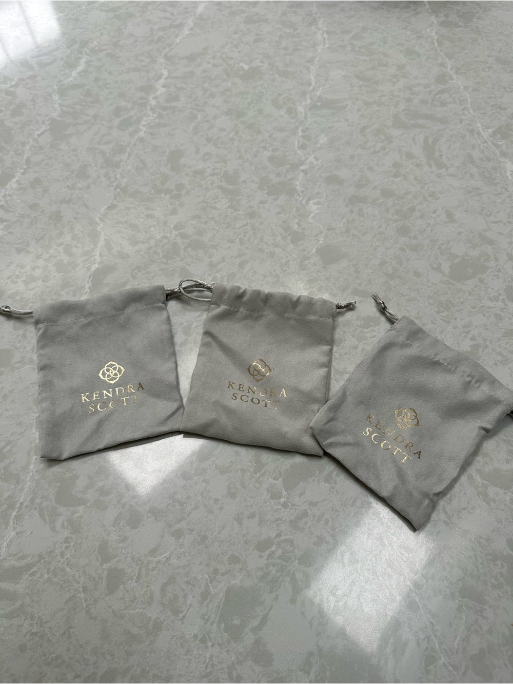 Kendra Scott Gray Drawstring Jewelry Pouches with Gold Logo